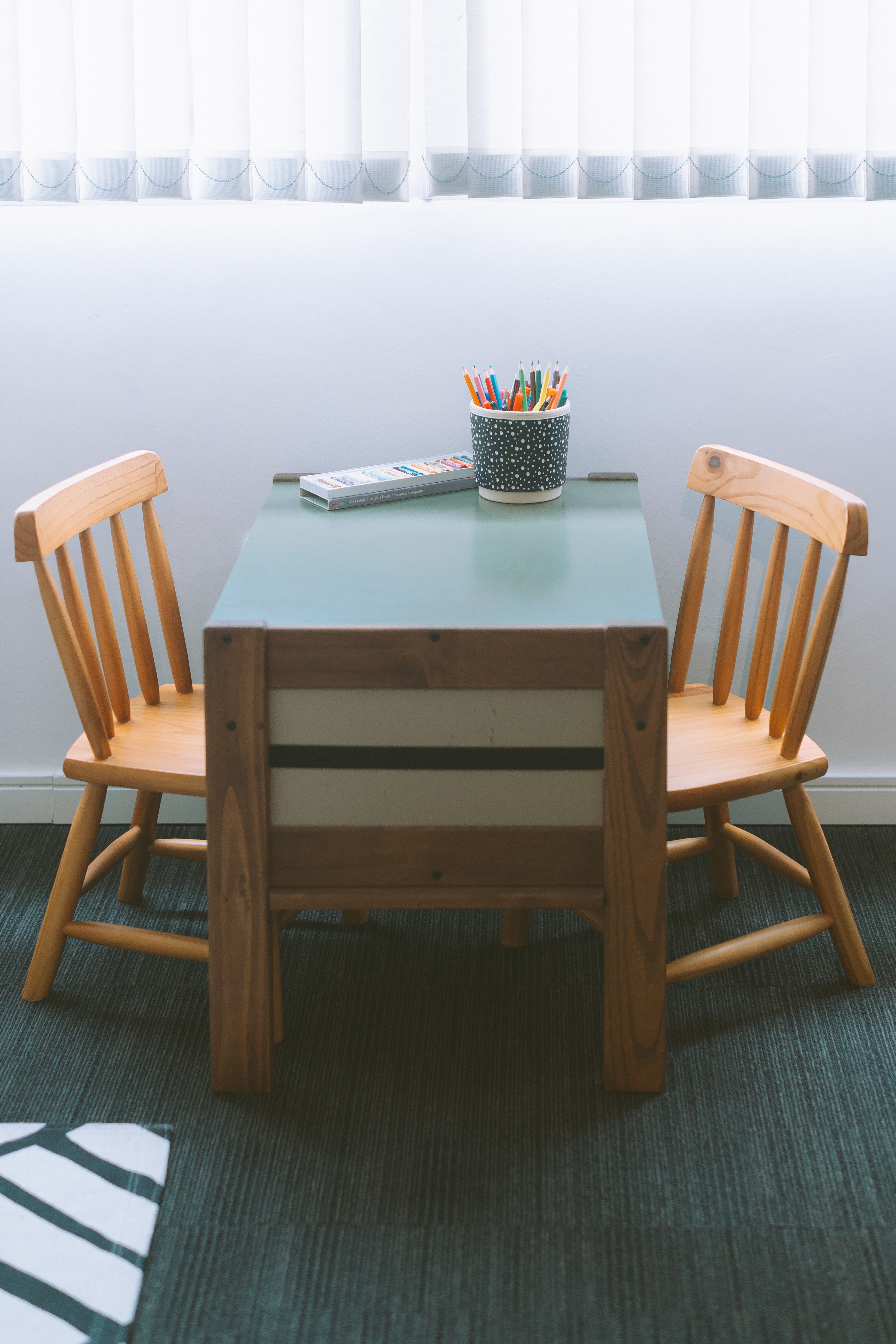 Mesa com lápis coloridos e cadeiras